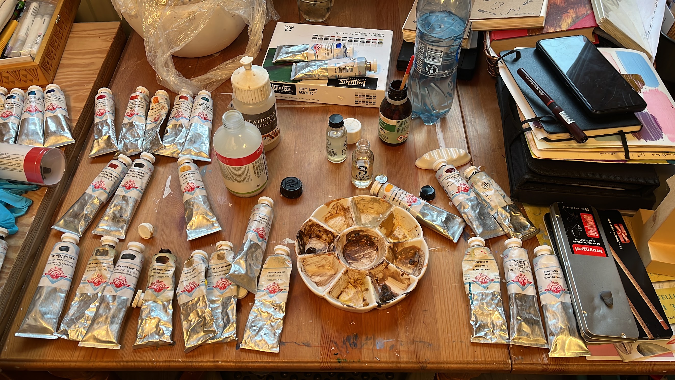 Verftubes, penselen en keramiekgereedschap klaargelegd op de werktafel