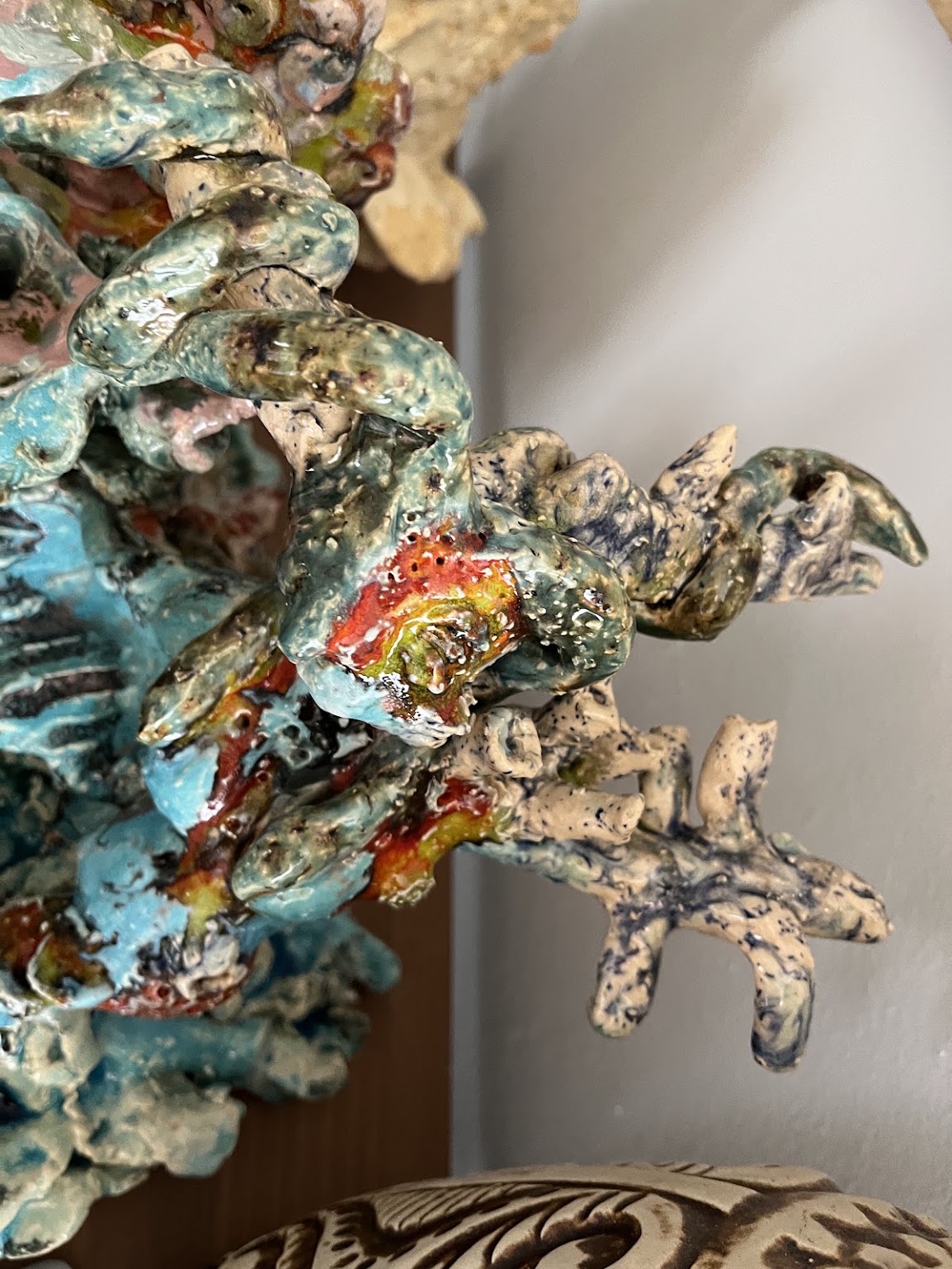Detail van een geglazuurd keramisch object met blauwe en okerkleurige accenten